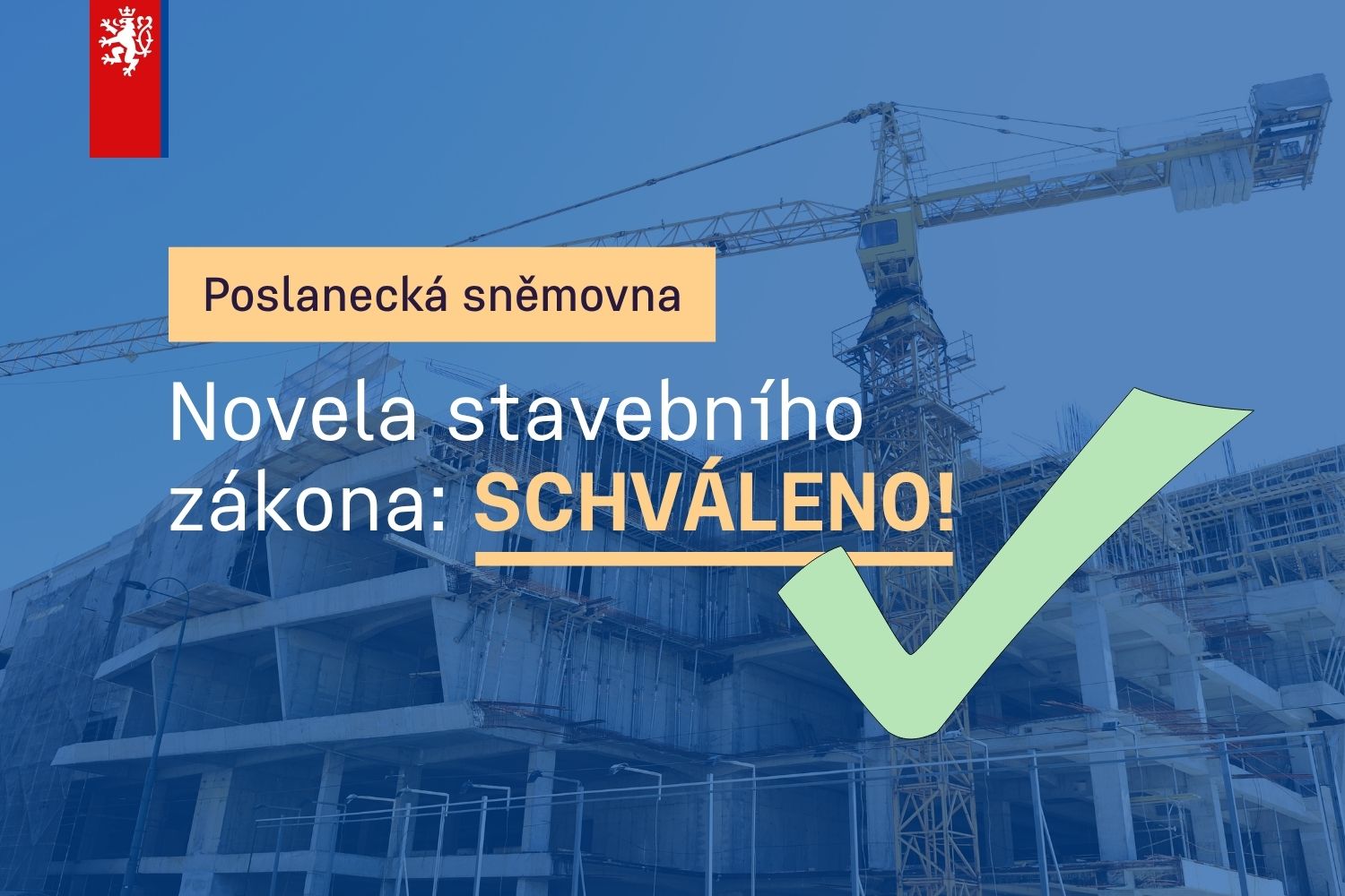 text Schváleno a stavba za ním v pozadí